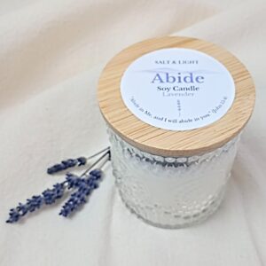 Candle in angled shot with bamboo lid on, lavender stems, soy wax