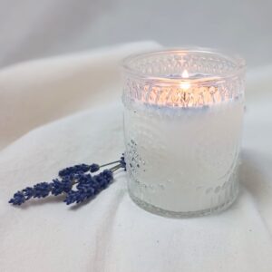 Clear glass soy candle with a bamboo lid, scented with pure lavender, displayed simply on a neutral background.